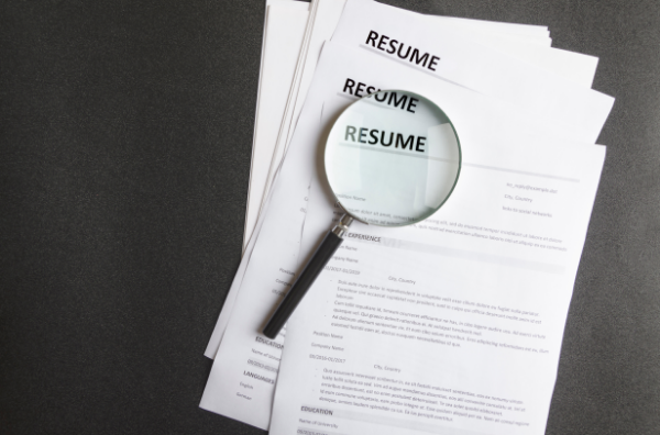 Stack of Resumes with magnifying glass
